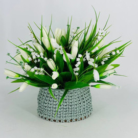 Bouquet of artificial flowers in a knitted flower pot