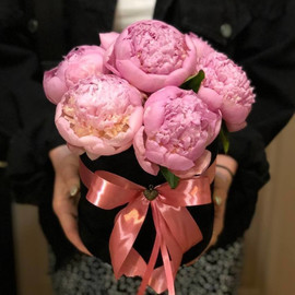 Lush pink peonies in a hat box