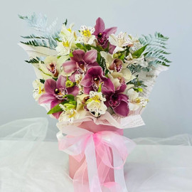 Delicate bouquet of orchids and alstroemerias in a hat box