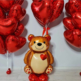 Giant teddy bear balloon with heart shaped balloons
