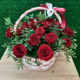 Basket of red roses in greenery