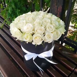 35 white roses in a black hat box