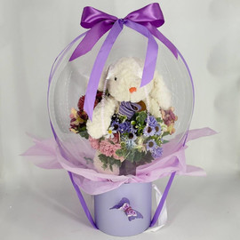 A bouquet of artificial flowers with a bubble ball and a plush bunny
