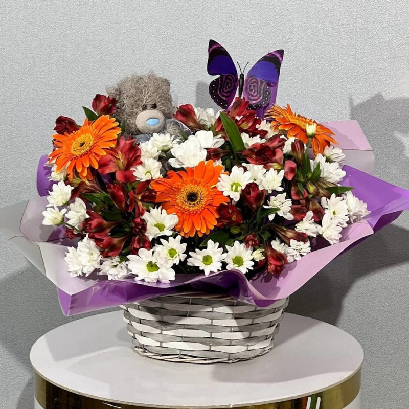 Bright bouquet in a basket with a soft toy in the form of a teddy bear, standart