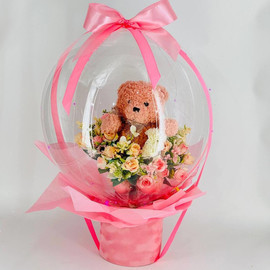 Gift for discharge from the maternity hospital: a bouquet of artificial flowers with a ball and a soft toy