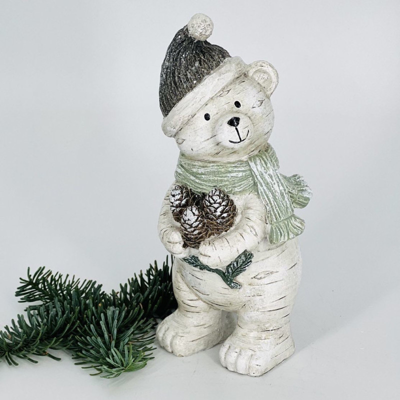 New Year's souvenir polar bear in a hat with an armful of pine cones, standart