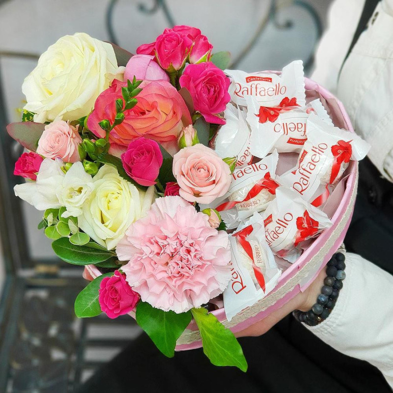 Composition of roses, carnations with Raffaello sweets in the shape of a heart, standart