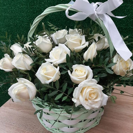 Basket of white roses in greenery