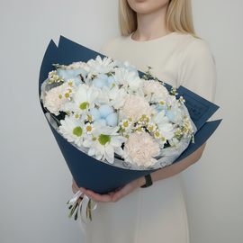 Buket iz romashkovih hrizantem, kremovih gvozdik, polevoj romashki i golubogo hlopka