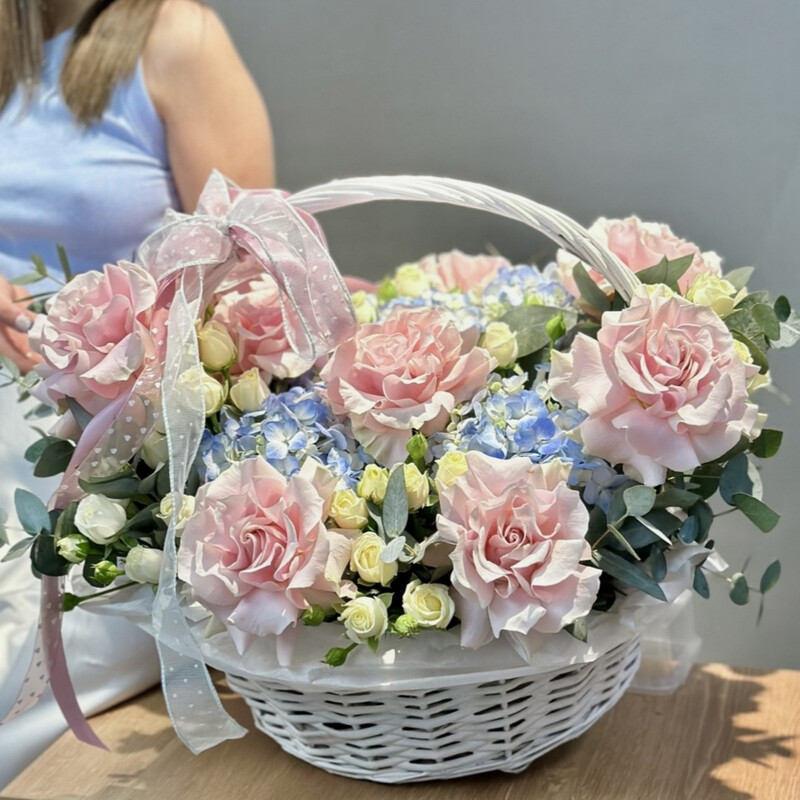 Delicate basket of blue hydrangeas, French and bush roses, standart