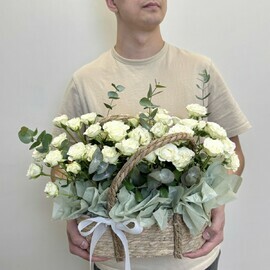 Belosnezhnaya kustovaya roza v korzinke s evkaliptom