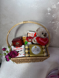A basket with a teddy bear, tea and sweets 