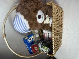 Basket with teddy bear, jam and sweets 
