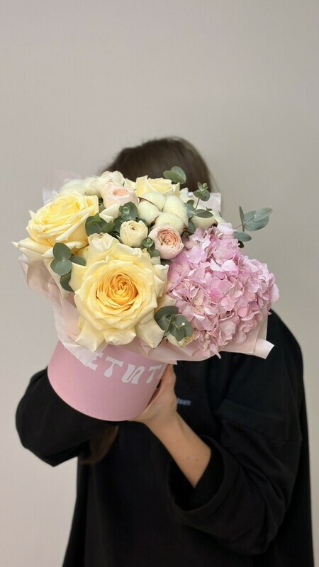 A delicate composition in a hatbox with peony-shaped roses, standart
