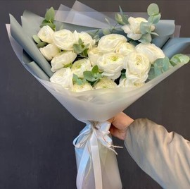 19 белых ранункулюсов с веточками эвкалипта в дизайнерской упаковке
