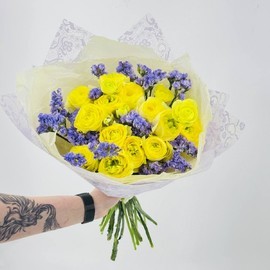 Buket iz zhyoltih limonnih ranunkulyusov s vetochkami statitci