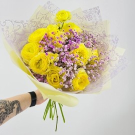 ZHyoltie ranunkulyusi s vetochkami gipsofili. YArkij buket ranunkulyusov