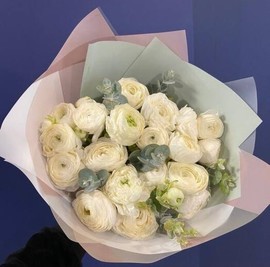 Nezhnie belie ranunkulyusi-lyutiki v dizajnerskoj upakovke. Buket iz ranunkulyusov