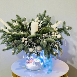 Novogodnij buket iz zhivogo nobilisa v steklyannoj vaze so svechoj