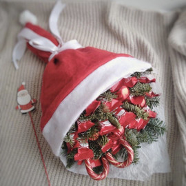 Novogodnij buket v kolpake Deda Moroza so sladostyami i vetochkami nobilisa